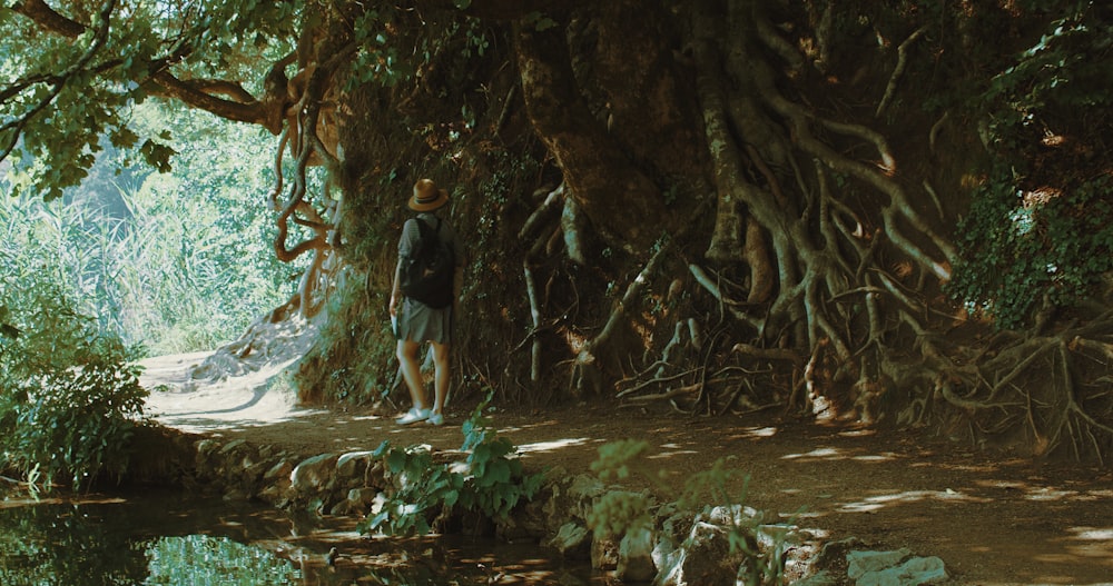 man in black t-shirt and blue denim shorts standing on river