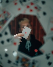 person holding 2 of diamonds playing card