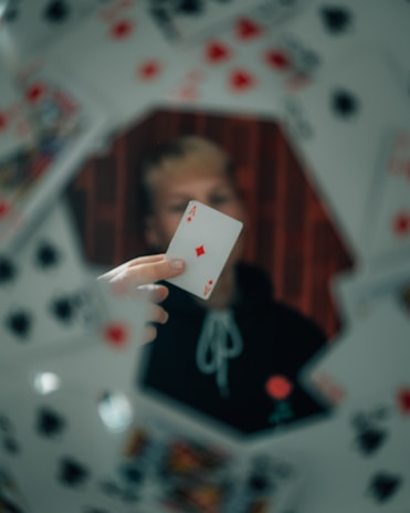 person holding 2 of diamonds playing card