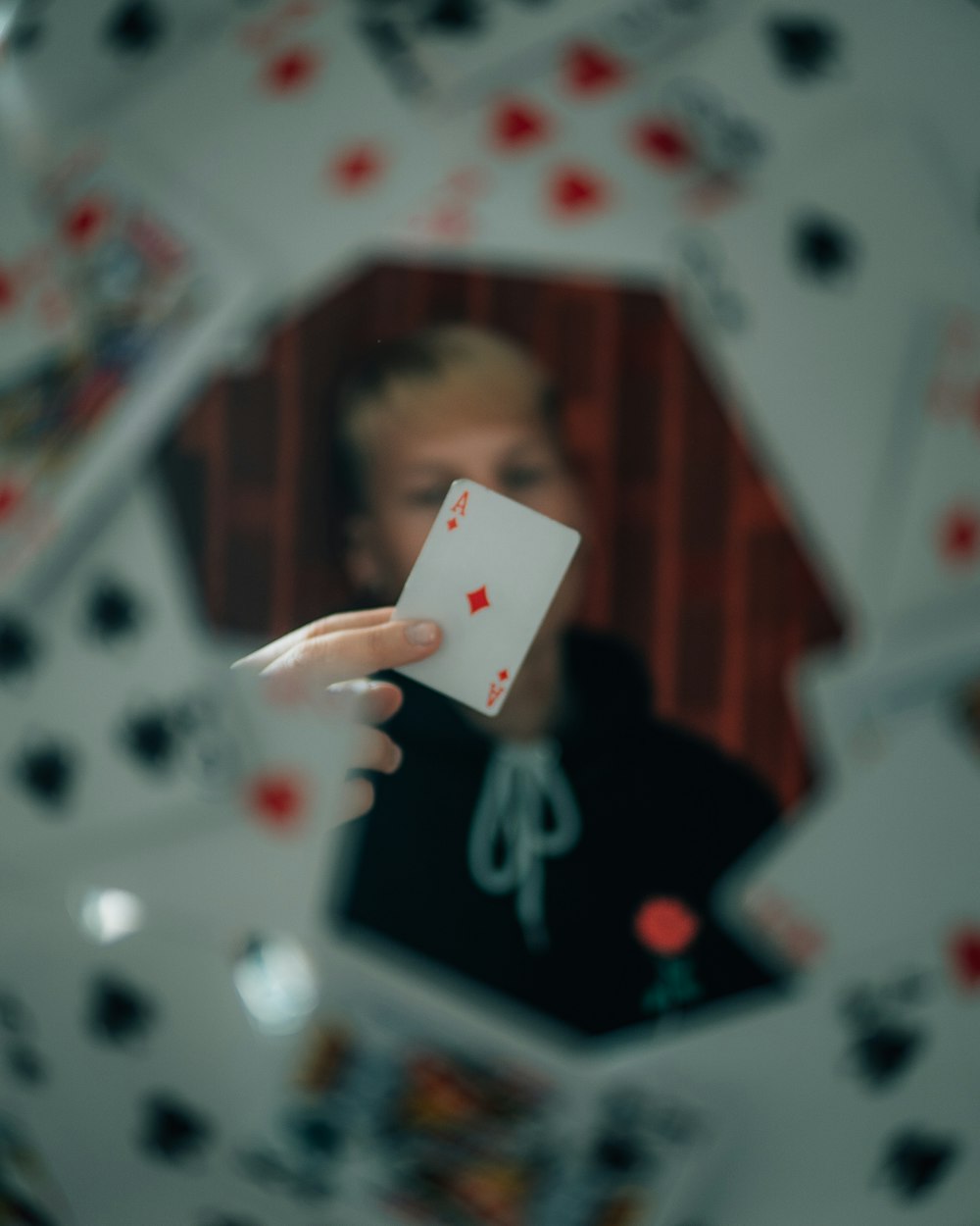 person holding 2 of diamonds playing card