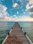 brown wooden dock on sea under blue sky during daytime