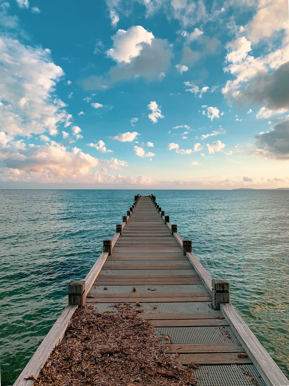 Braunes Holzdock auf See unter blauem Himmel tagsüber