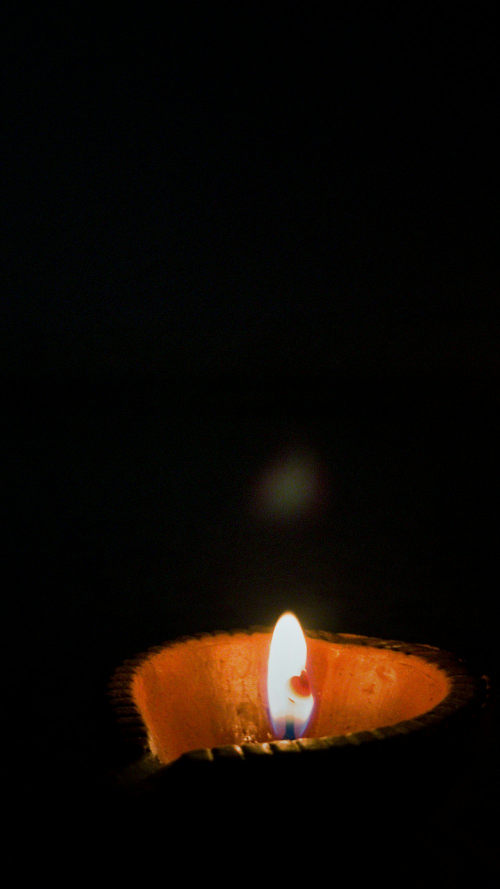 lighted candle in dark room