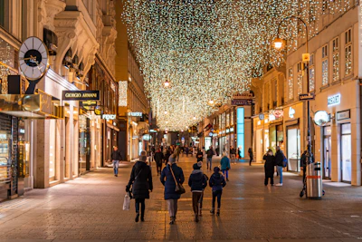 people walking on a pedestrianised shopping street in Vienna during night time