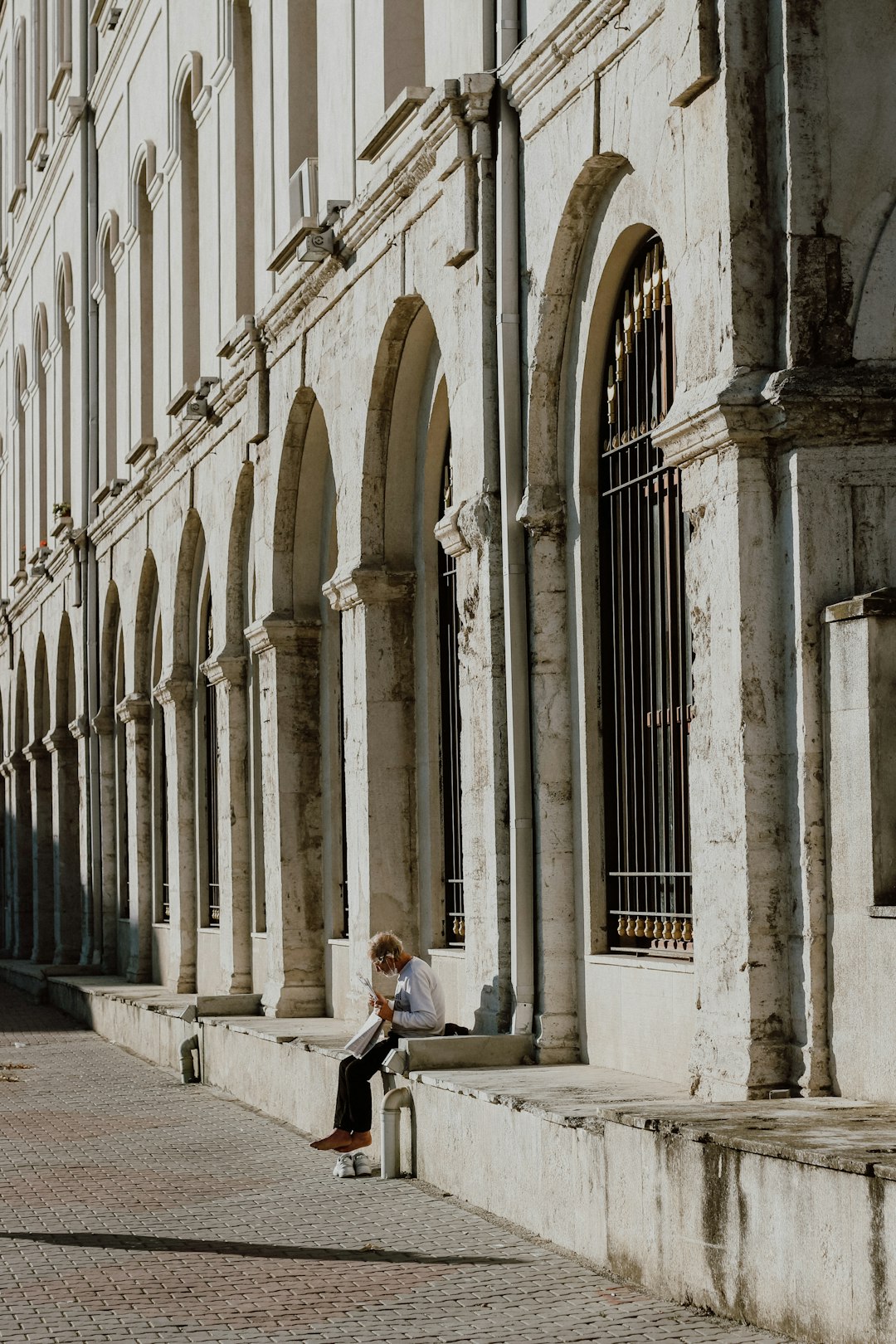 man in black suit standing near white concrete building during daytime