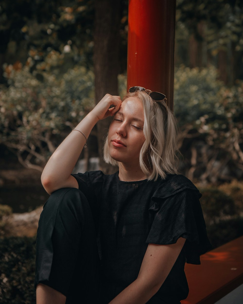 woman in black button up shirt holding on red post