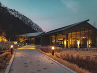 Evening scene of the school building illuminated in the school colors, inviting and modern.