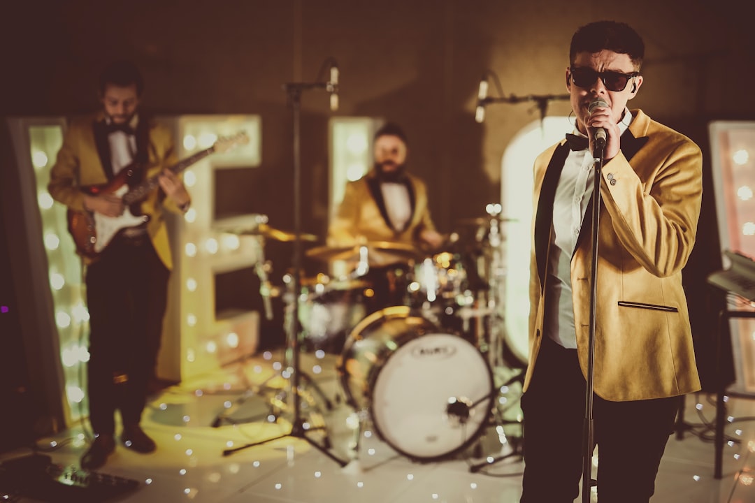 24K Motown & Soul Band singing and performing live for a new video, wearing gold jackets and tinted sunglasses - bringing style and class to the lit dancefloor.