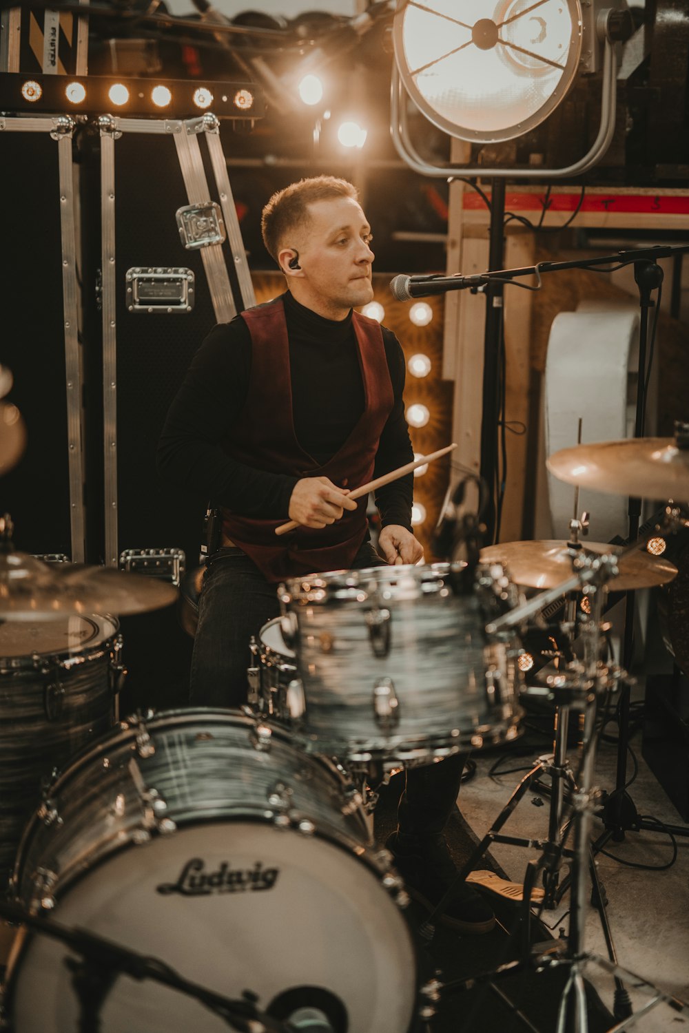 man in black long sleeve shirt playing drum