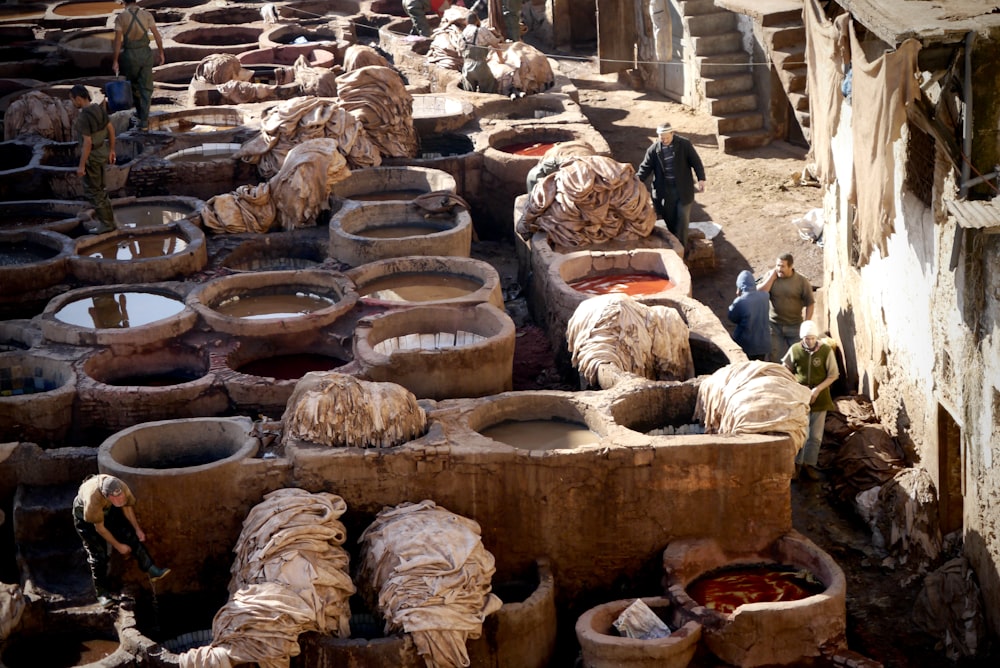 brown wooden barrels on brown sand during daytime