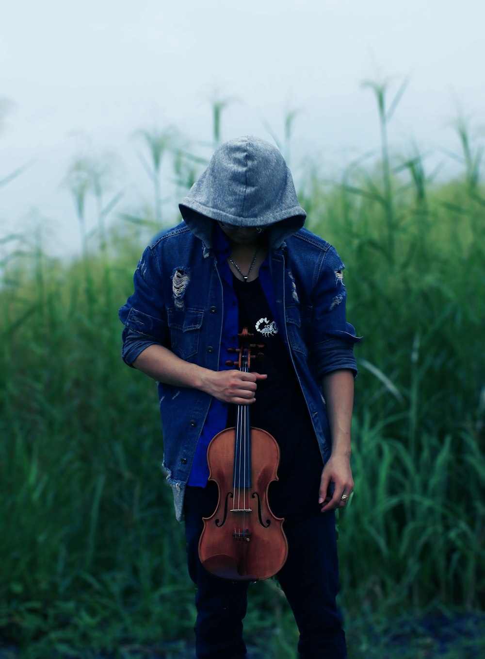man in blue jacket and gray knit cap playing violin