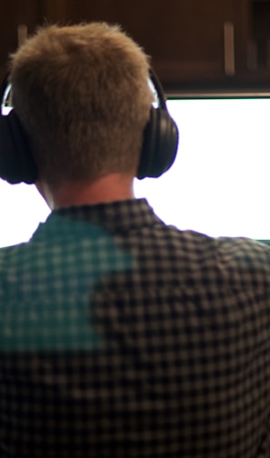 man in blue and white plaid shirt wearing black headphones