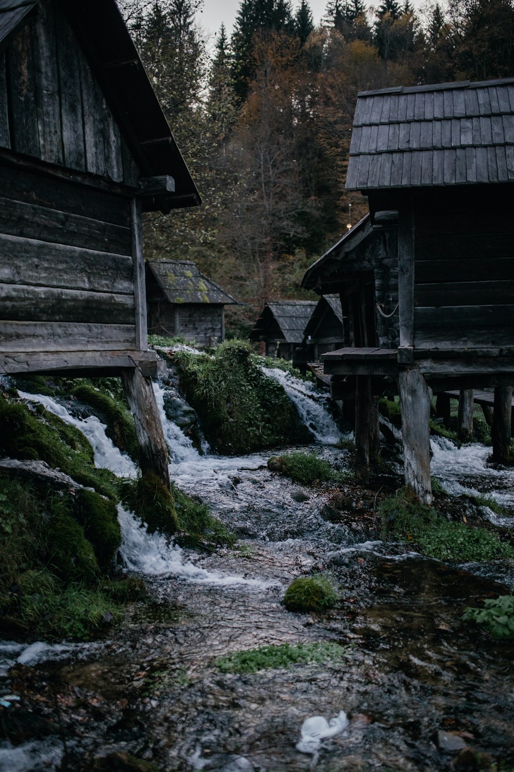 brown wooden house on rocky river