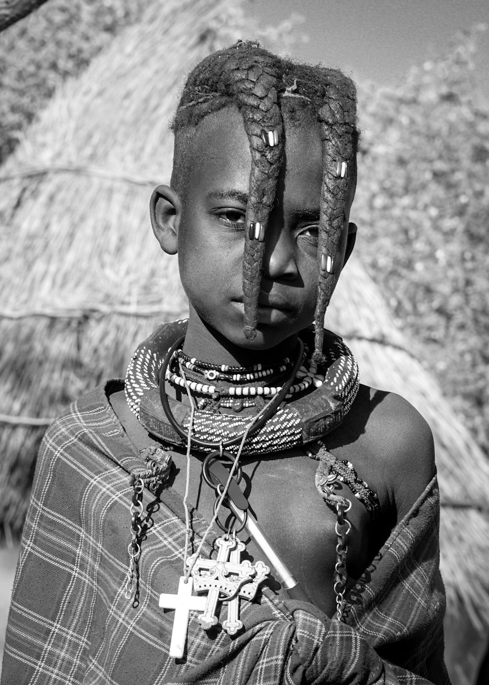 grayscale photo of child wearing beaded necklace