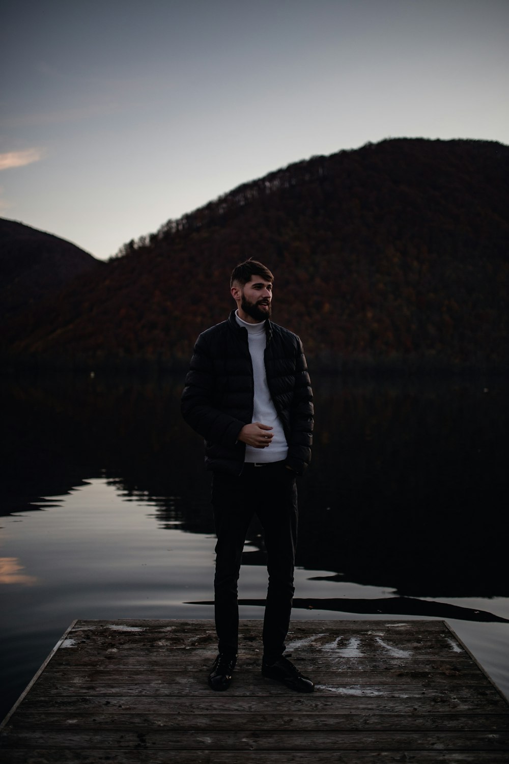 man in black jacket standing on the shore