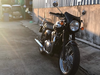 A striking shot of a custom motorcycle parked beside film equipment, bathed in warm sunset light.