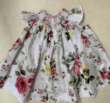 A whimsical dress adorned with floral patterns and ribbons.