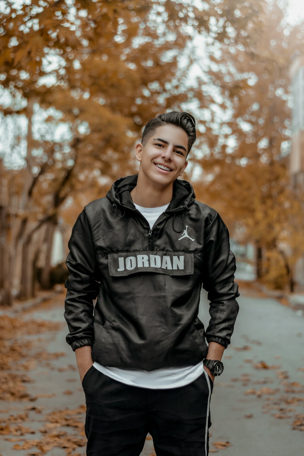 man in black leather jacket standing on road during daytime