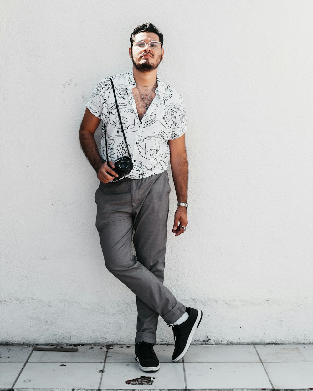 man in gray polo shirt and black pants wearing black sunglasses