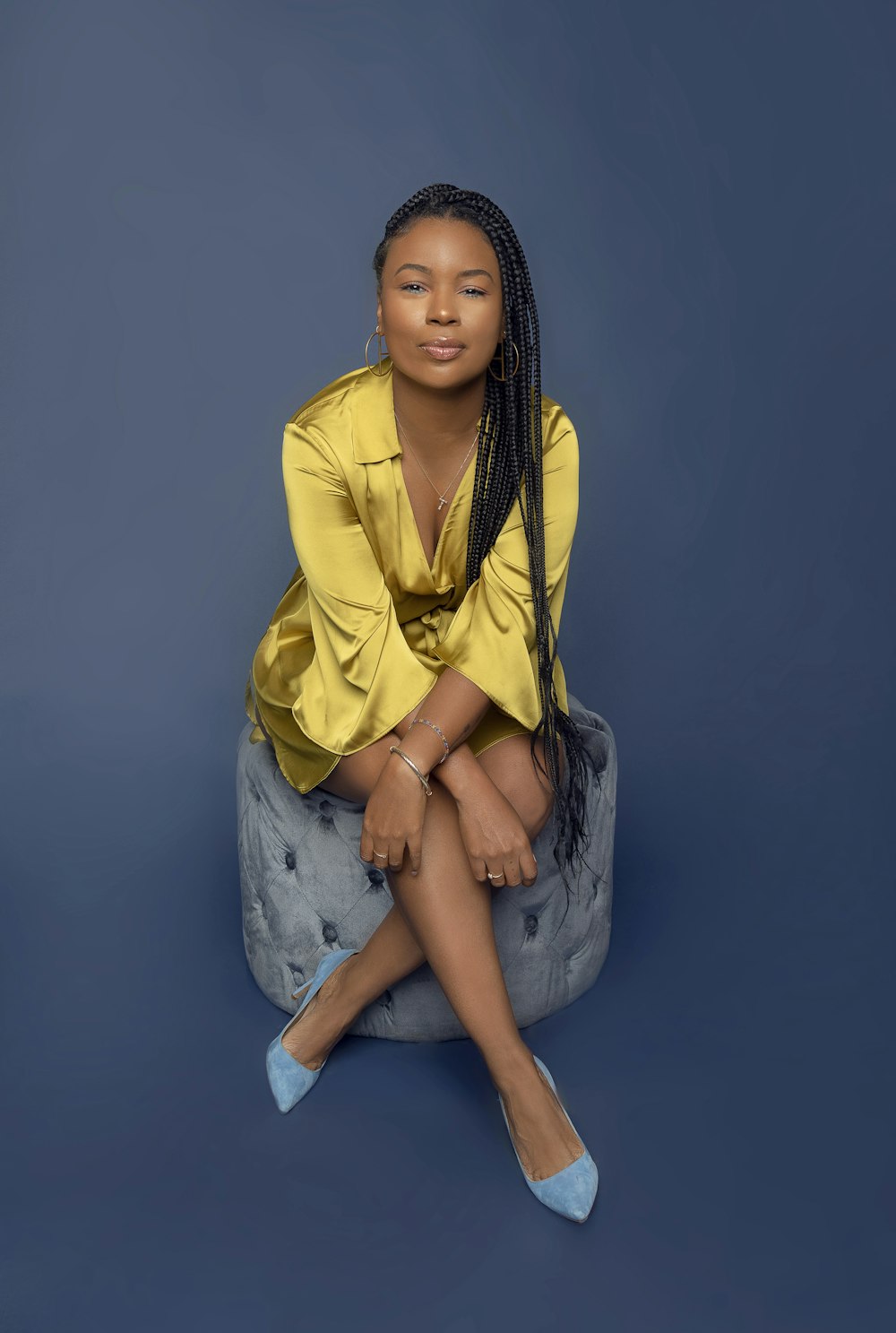 woman in yellow button up shirt sitting on gray rock