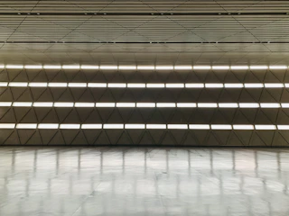 Spacious event room with minimalist decor and elegant lighting.