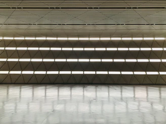 Modern glass and aluminum installation in a sleek, minimalist interior with warm lighting.