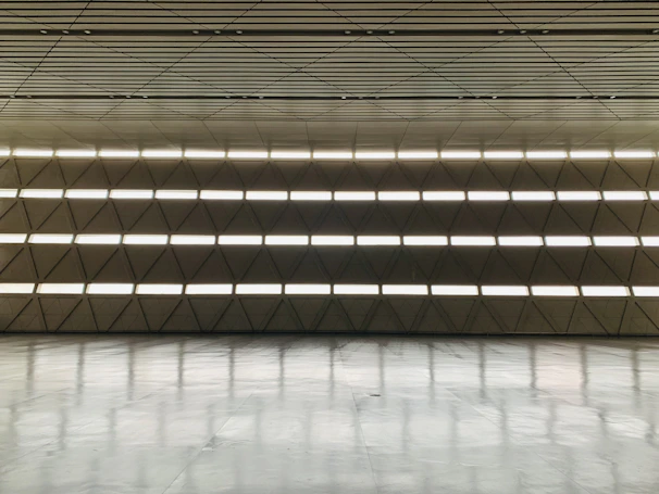 Modern glass and aluminum installation in a sleek, minimalist interior with warm lighting.