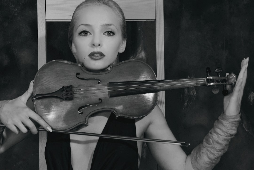 woman playing violin grayscale photo