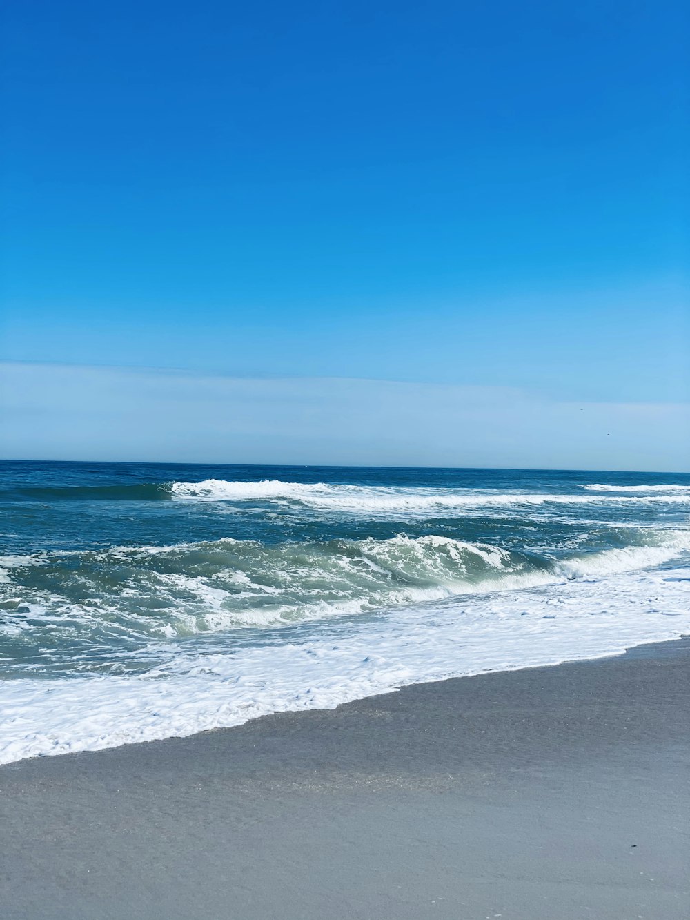 ocean waves crashing on shore during daytime