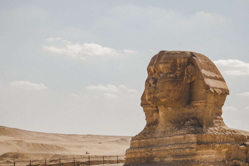 brown rock formation under white clouds during daytime