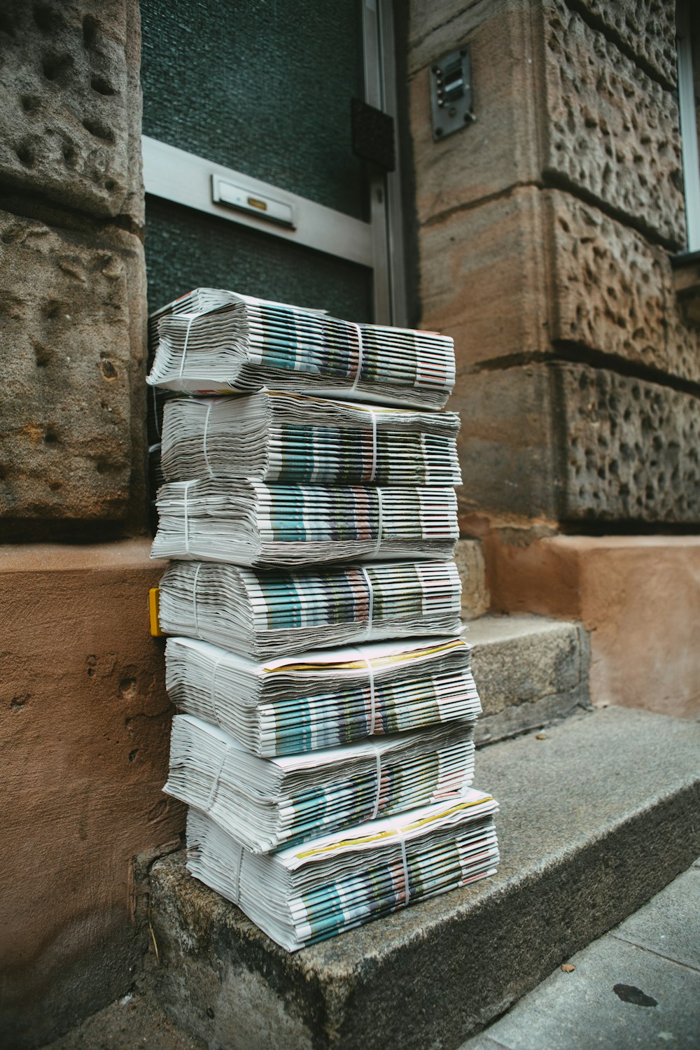 stack of white and blue books on brown concrete floor