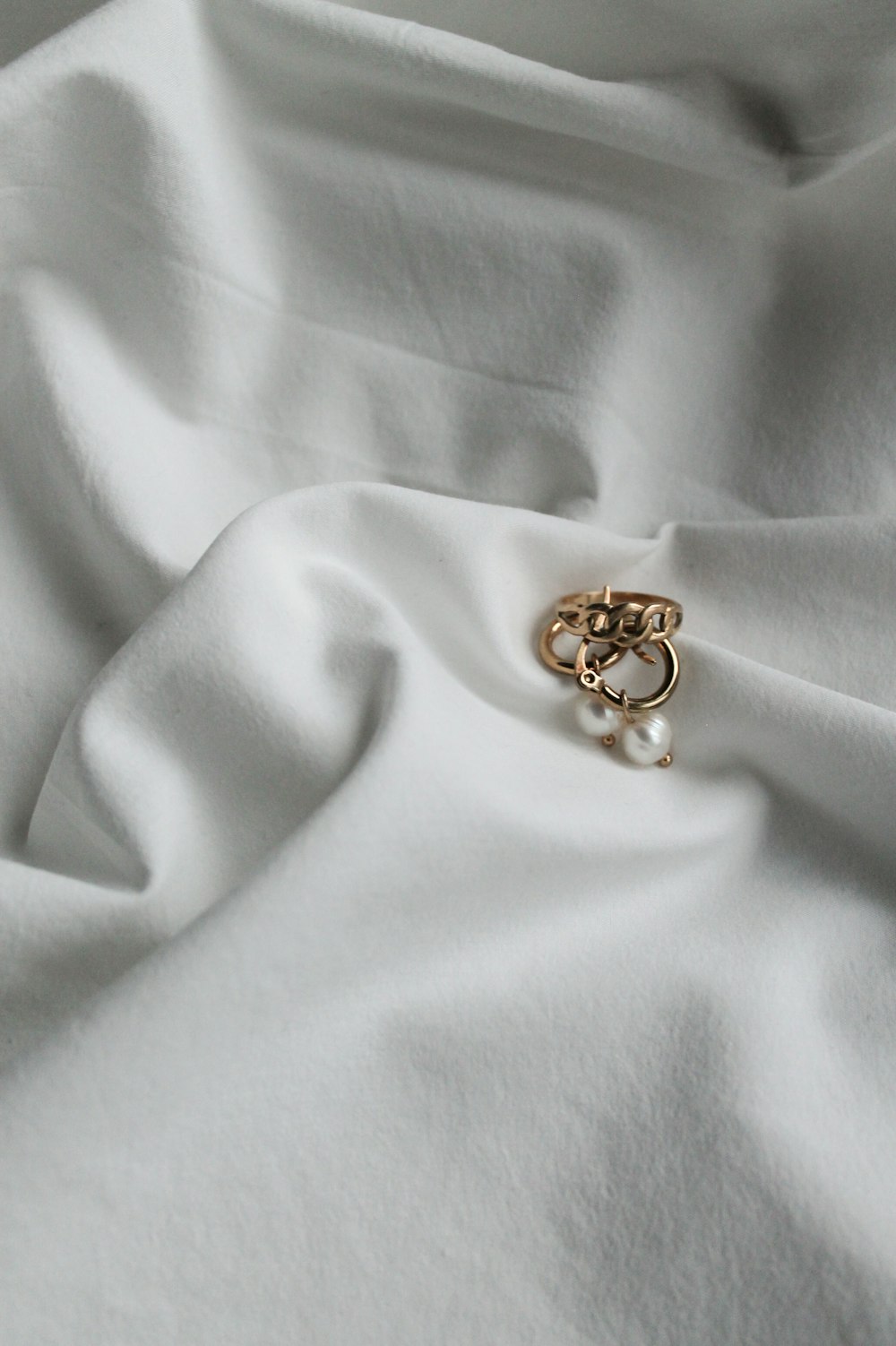 gold ring on white textile