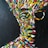 A vibrant abstract painting depicts a human face composed of bold, colorful brush strokes against a dark background. The colors include red, blue, green, yellow, and white, creating a dynamic and energetic appearance. The lines and colors form an impressionistic portrait with an impression of motion and vitality.