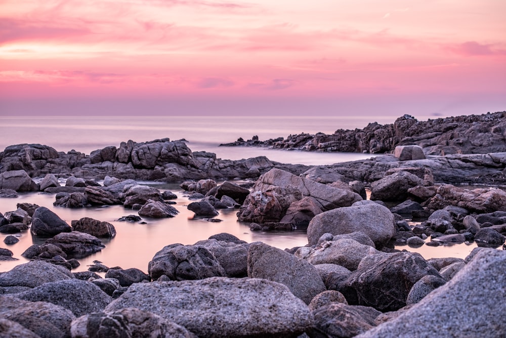 rocky shore under cloudy sky during daytime