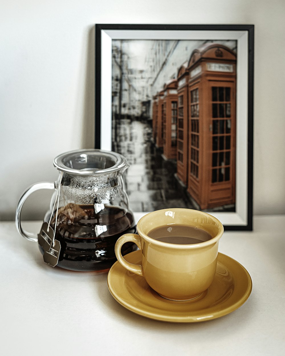 orange ceramic mug on saucer beside clear glass pitcher