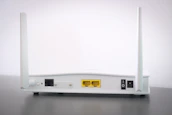 A variety of modern modems and routers displayed on a wooden table.