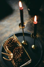 Wide trunk hinge parts displayed alongside glass candle urn hang hardware on a rustic table.