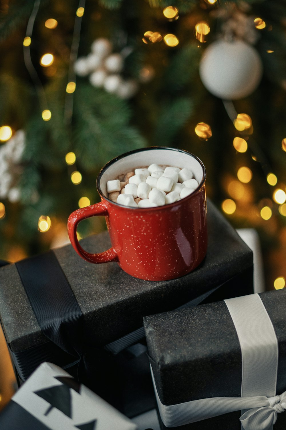 white and red ceramic mug on black box