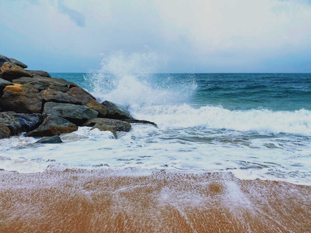 ocean waves crashing on rocky shore during daytime