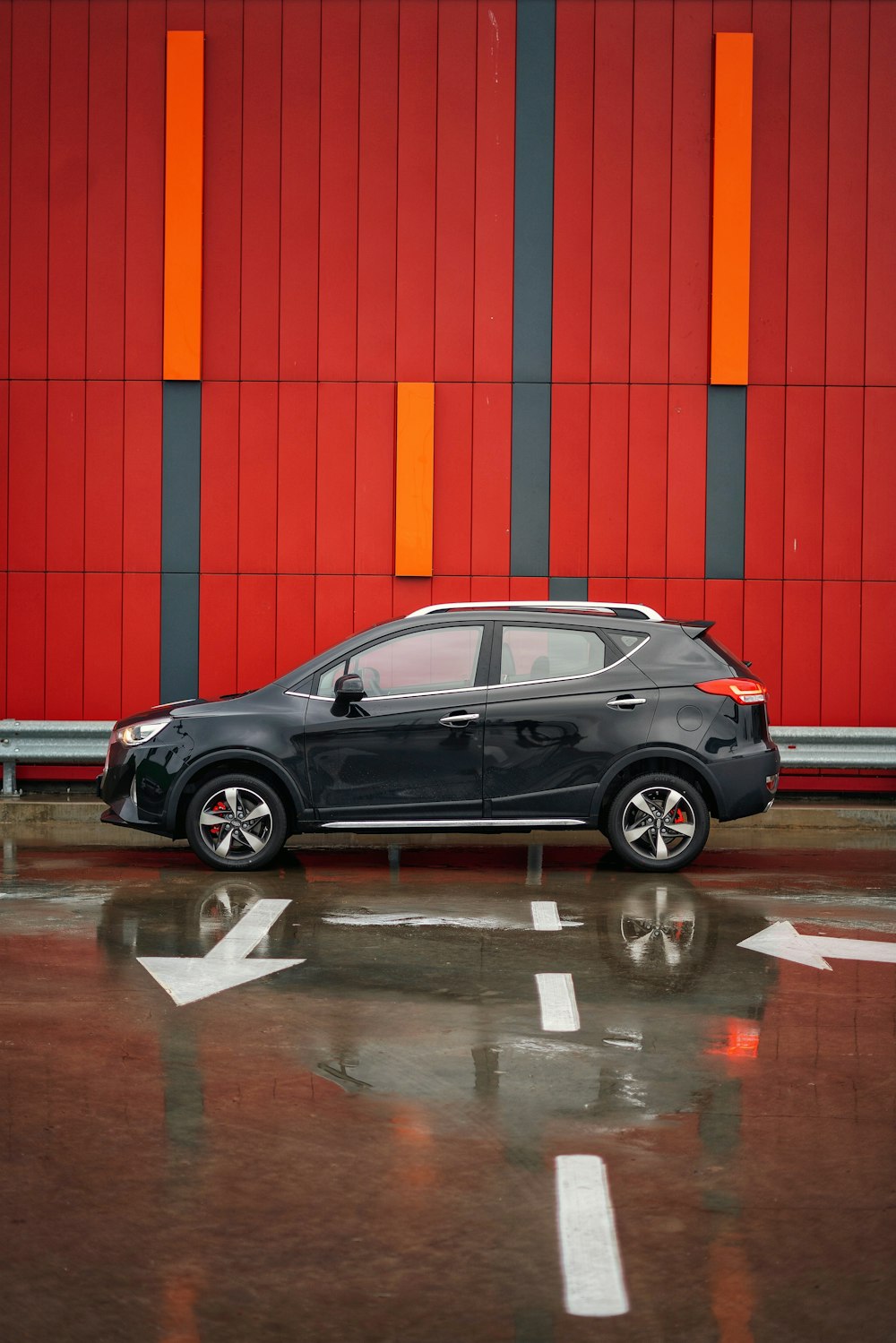 black sedan parked beside red and white building