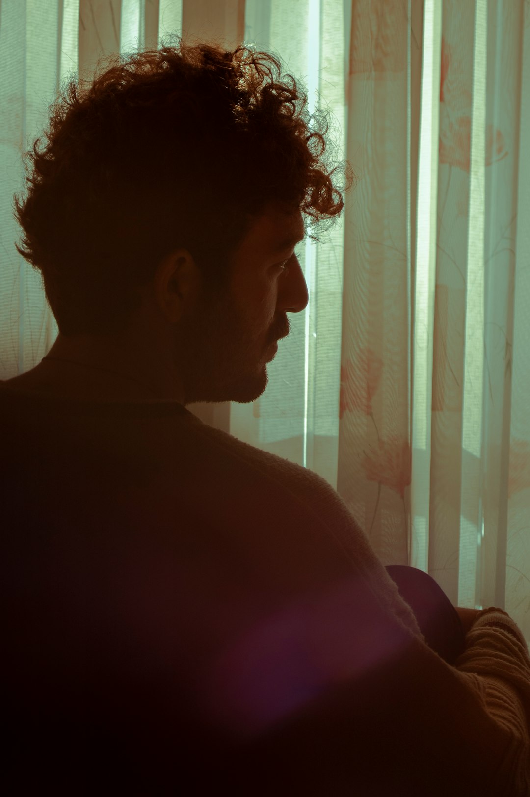 woman in pink shirt standing near window