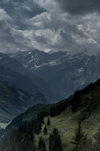 green and black mountains under white clouds during daytime