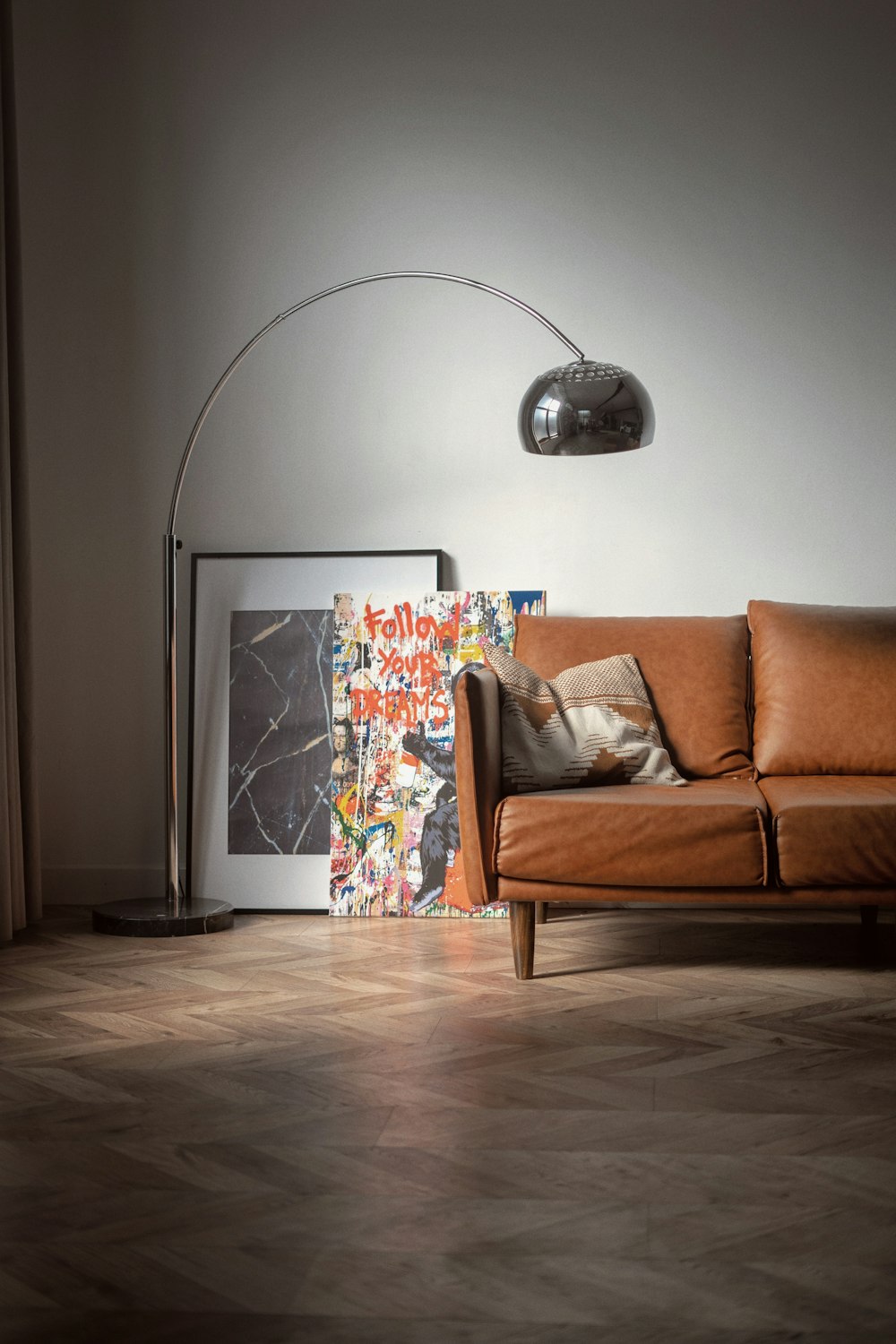 brown wooden framed white padded armchair beside white wall