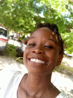 A vibrant portrait of a smiling individual in a natural setting.