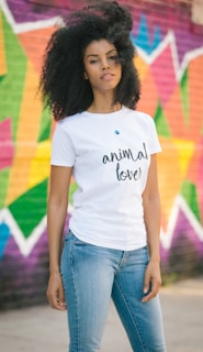 woman in white crew neck t-shirt and blue denim jeans standing on purple and yellow