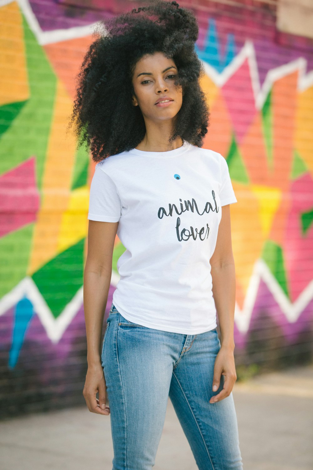 woman in white crew neck t-shirt and blue denim jeans standing on purple and yellow