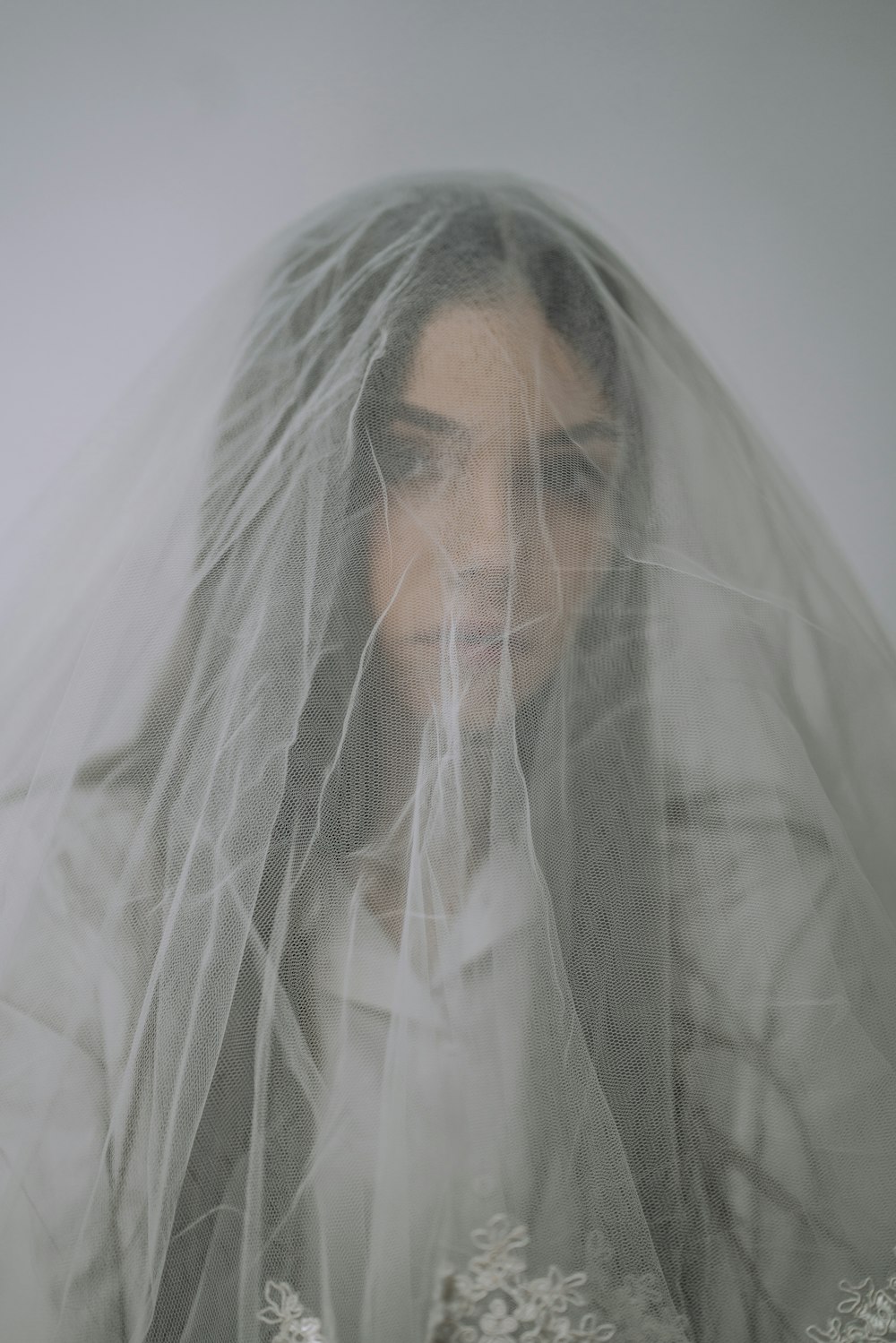 man in white veil covering his face with white textile