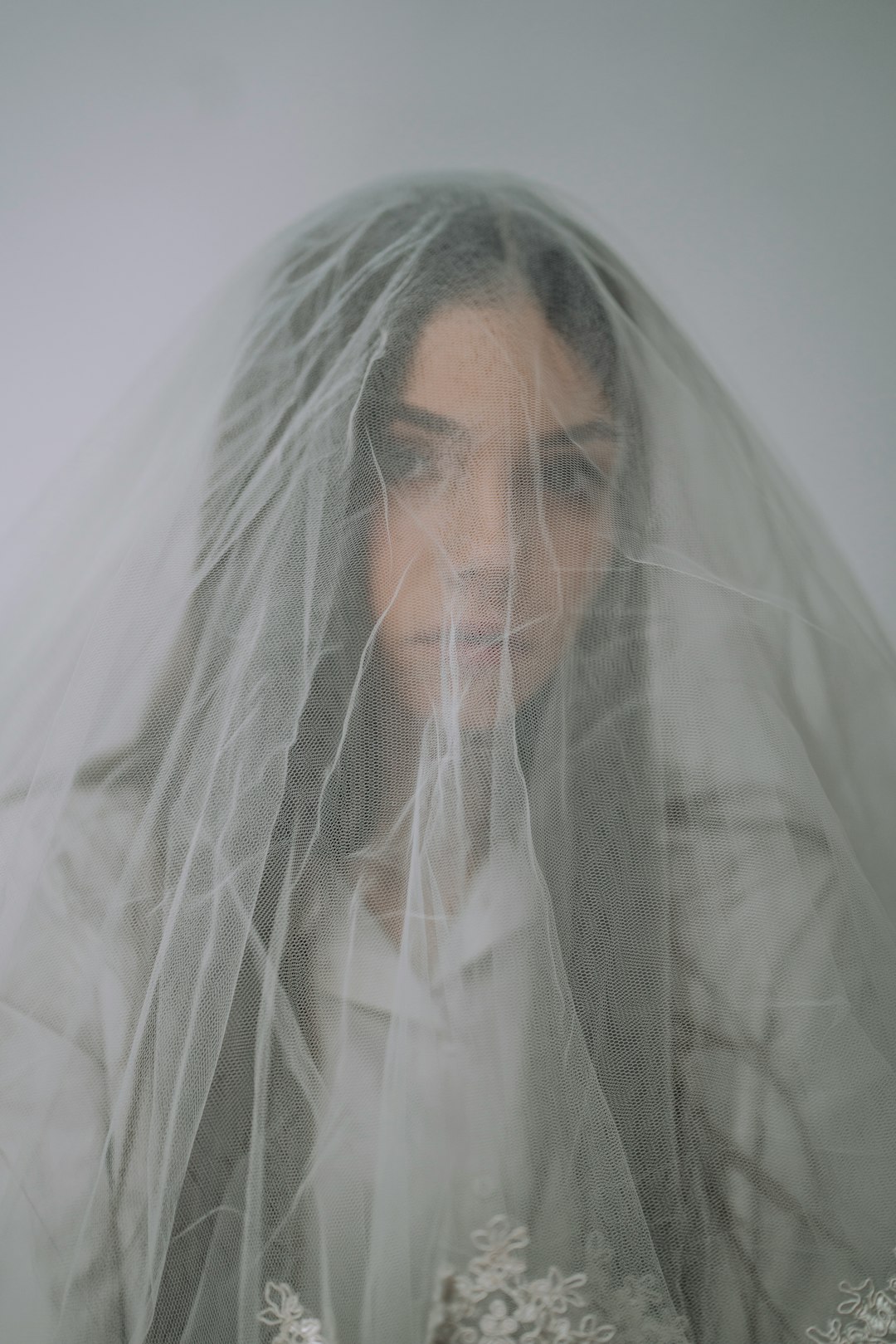 man in white veil covering his face with white textile