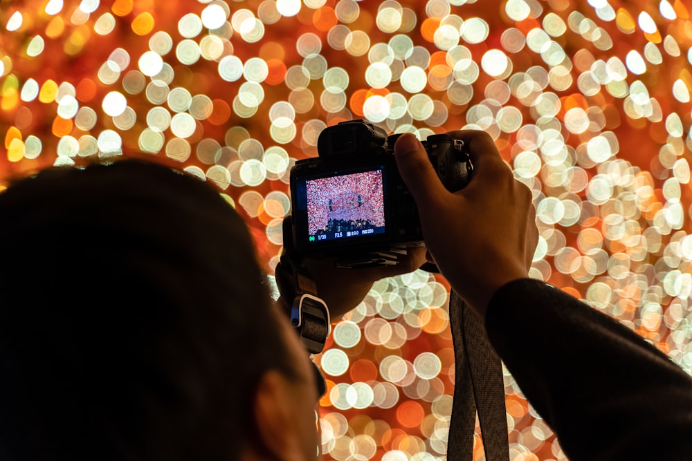 Person mit schwarzem Smartphone beim Fotografieren von Lichtern