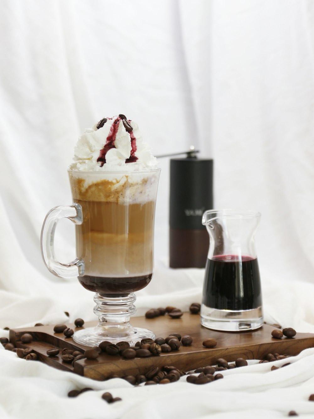 a cup of coffee with whipped cream and coffee beans